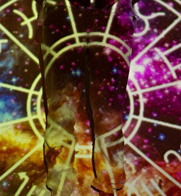 Silhouette of a person in an energetic yoga pose with aquamarine light trails.